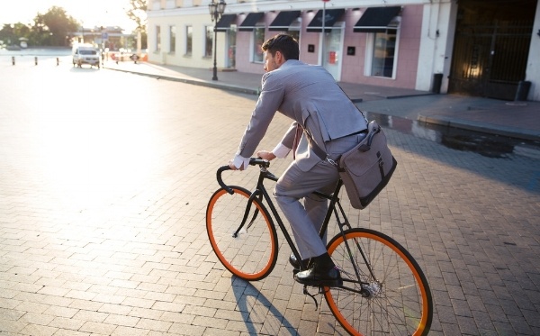Businessman riding bicycle to work on urban street in morning-784150-edited